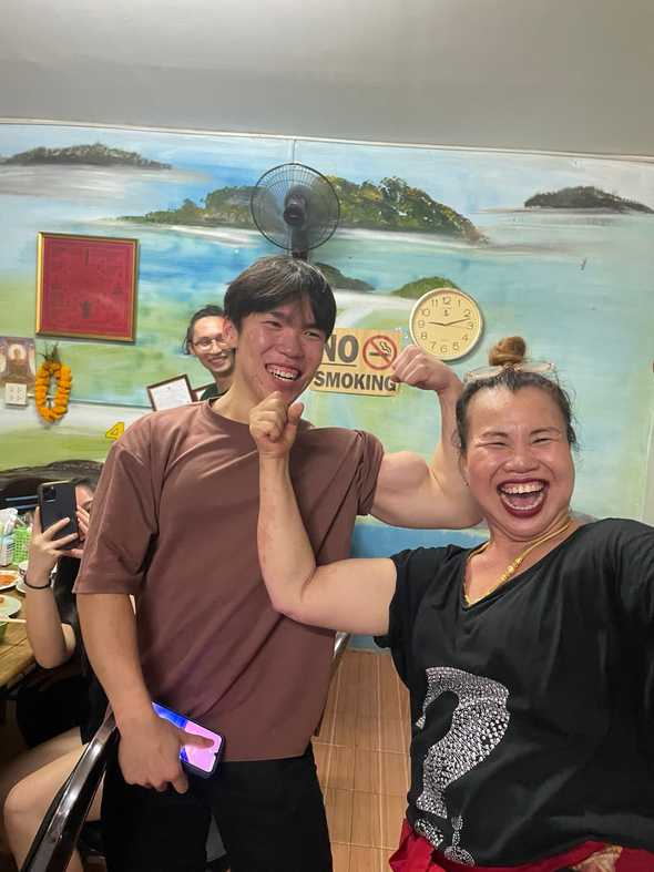 Wan Loong flexing his biceps with a local